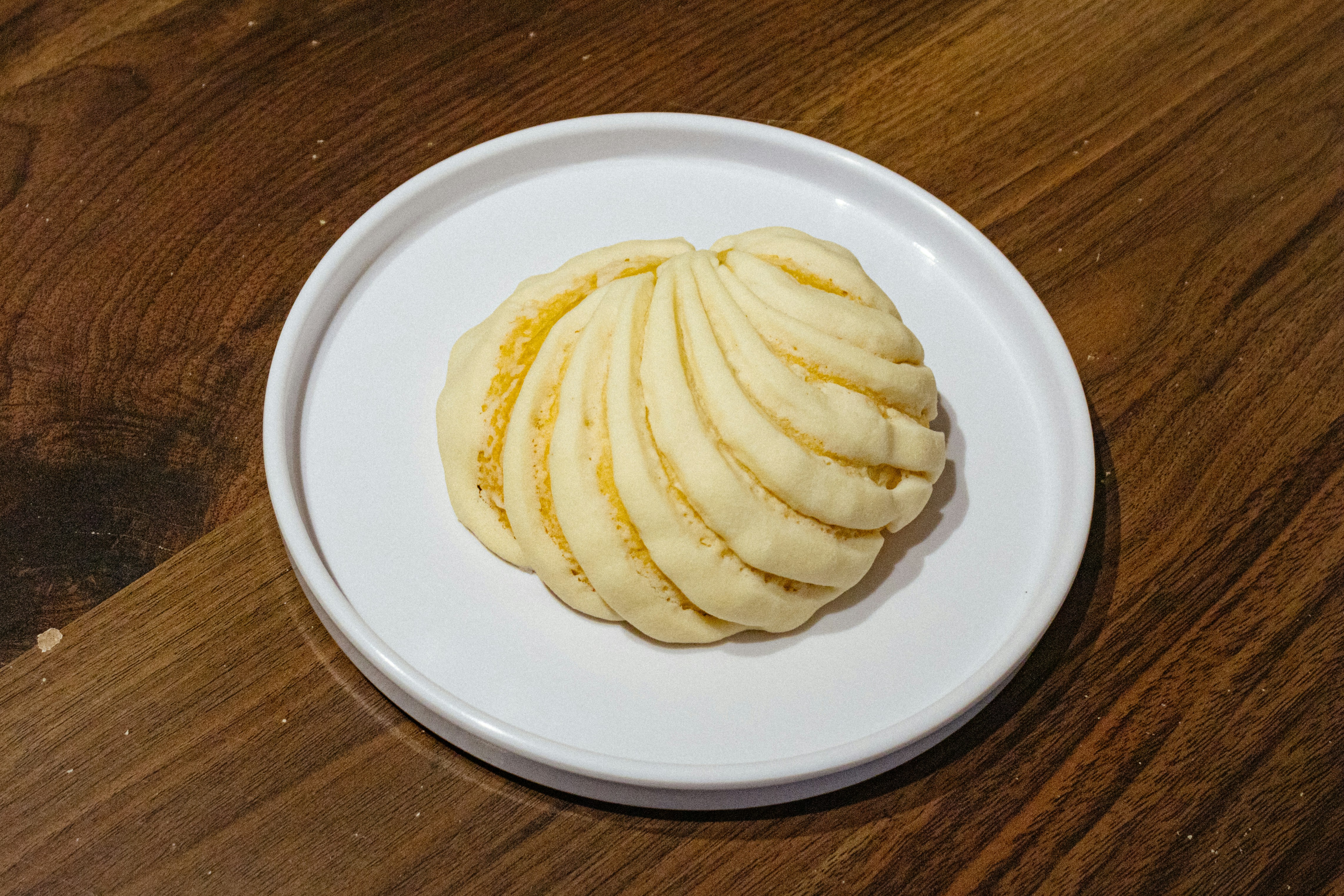 チーズ入り、半熟卵入り、スパイシー仕立てなど、数種類のカレーパンが木のプレートに並んでいる様子